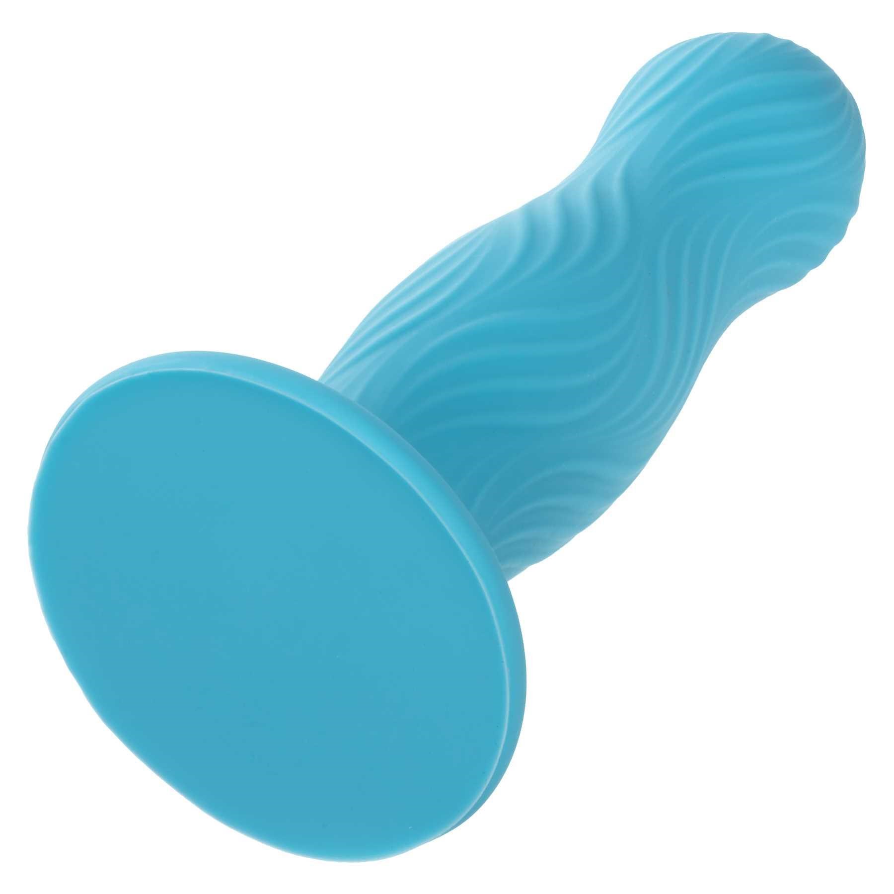 Wave Rider Swell Liquid Silicone Dildo laying on table suction end forward